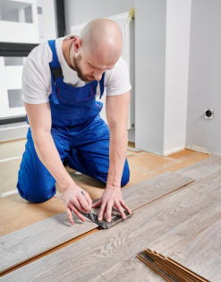 Skilled handyman installing laminate flooring seamlessly in a modern home.