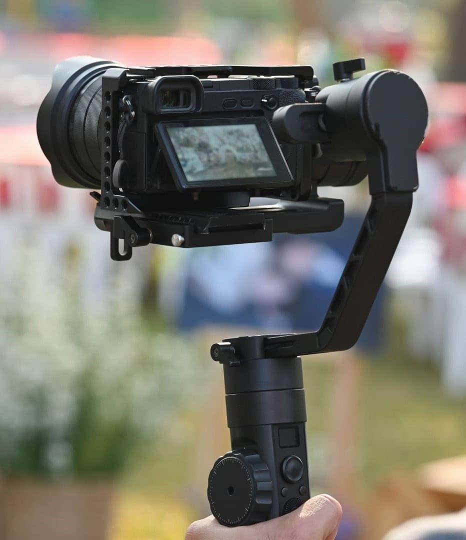 Close-up of a gimbal stabilizer with a camera attached, used for smooth video shooting.